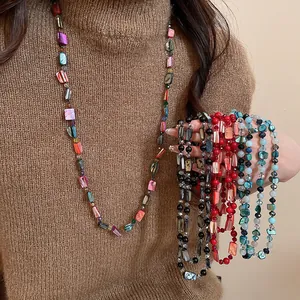 Close-up detail of bohemian style shell and glass bead long necklaces for women
