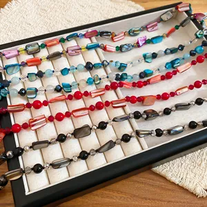 Macro view of colorful beaded necklaces with shell-like pieces in a jewelry tray