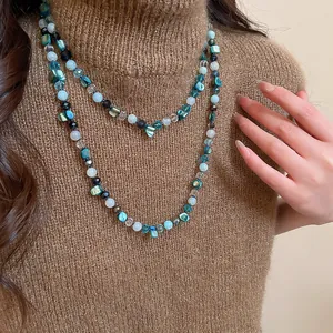 Close-up of double-layered beaded necklace with blue faux shells and glass beads.