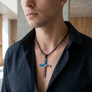 Detail shot of a stainless steel American flag cross pendant worn by a male model.