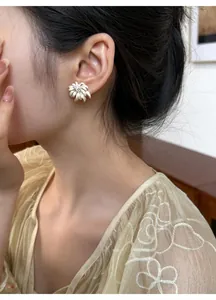 Detail view of elegant French style floral crystal stud earrings on an Asian model