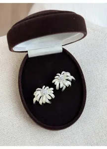 Detail view of firework-shaped silver earrings with dripping oil and crystals