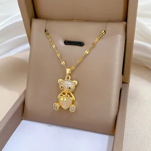 Detail of gold teddy bear pendant with sparkling zircons and champagne heart stone