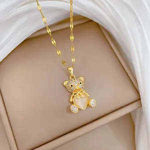 Macro shot of gold teddy bear necklace with heart opal and pavé crystals on silk