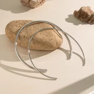 Minimalist polished stainless steel open choker neck rings set on stone background