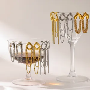 Elegante, 18 Karat vergoldete Edelstahl-Quastenkette-Ohrringe auf Glas präsentiert