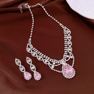 Detailansicht von Halskette und Ohrringen mit rosa Zirkon-Wassertropfen und Strass