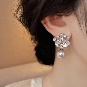 Exquisite close-up of French-style floral earrings with zircons and elegant drop pearls