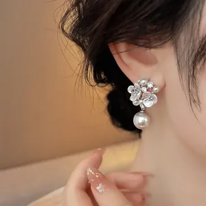 Elegant French-style flower earrings with sparkling cubic zirconia and drop pearl detail.