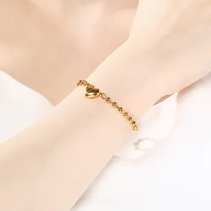 Primo piano di un bracciale a sfere dorate con chiusura a cuore magnetica
