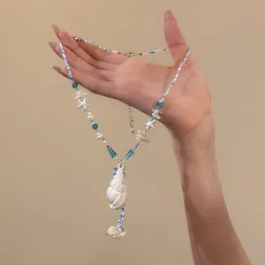 Detailed close-up view of a blue starfish and white conch shell beaded necklace for summer.
