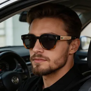 Detail of luxury polarized sunglasses with embossed gold metal temples and green gemstone