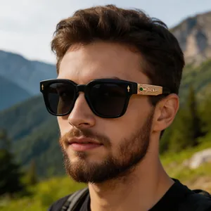 Detail of square polarized sunglasses with golden engraved temple and green gem accent