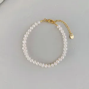 Close-up of baroque freshwater pearl bracelet with golden lobster clasp and tag