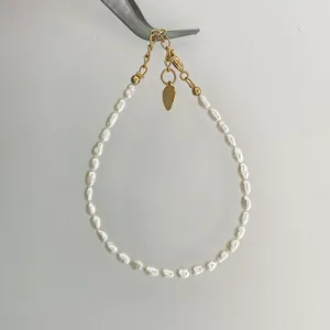 Detailed macro view of baroque freshwater pearl bracelet with golden heart charm