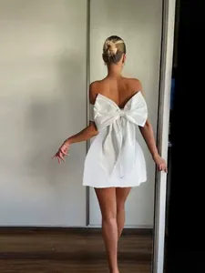 Elegant white strapless mini dress with a large decorative bow on the back