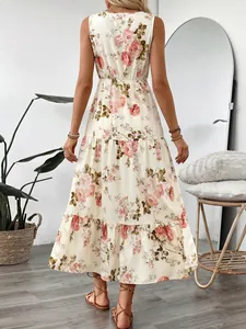 Détail de la robe longue fleurie à plusieurs niveaux montrant l'imprimé rose et les volants