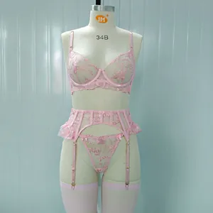 Dettaglio di ricamo floreale rosa e pizzo su un set di lingerie in rete con ferretto