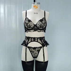 Dettaglio completo intimo in pizzo floreale nero con reggiseno con ferretto e reggicalze su manichino