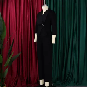 Détail d'une combinaison noire à col en V avec boucle dorée et pantalon large chic
