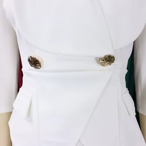 Détail de la taille d'une combinaison blanche avec boutons dorés et design croisé
