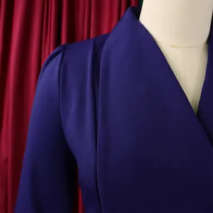 Détail d'une combinaison violet foncé avec épaules plissées et décolleté en V