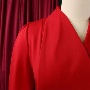 Détail du col d'un blazer rouge avec texture sergée et épaule plissée sur mannequin