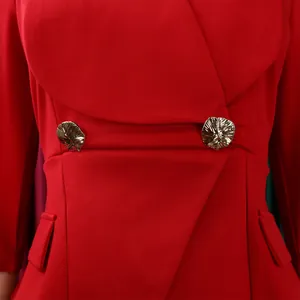Détail d'une combinaison rouge avec décolleté croisé et boutons dorés gaufrés