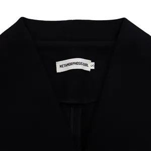 Détail de l'encolure de la combinaison noire avec étiquette de marque et taille S en gros plan