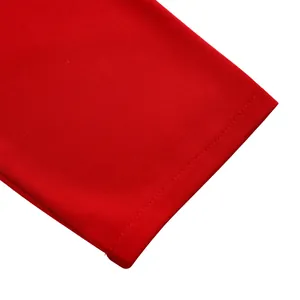 Gros plan sur l'ourlet de manche de combinaison rouge avec coutures doubles précises
