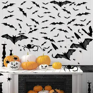 Détail de stickers muraux chauve-souris et araignée noirs sur fond de bois blanc