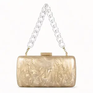 Close-up of champagne acrylic evening bag with pearlescent marble texture and chain