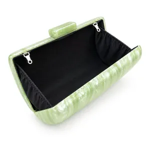 Detail view of the green marble acrylic evening bag with black lining and metal hooks