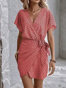 Détail de robe cache-cœur rose à col en V avec imprimé géométrique et ceinture