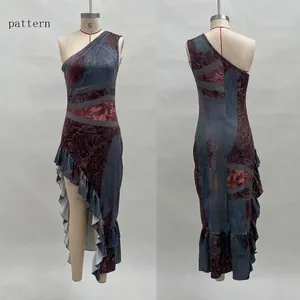 Detail of vintage paisley print and ruffled hem on asymmetric off-shoulder dress