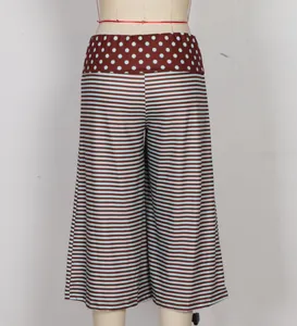 Detail of wide-leg shorts featuring polka dot waist and blue-brown striped fabric