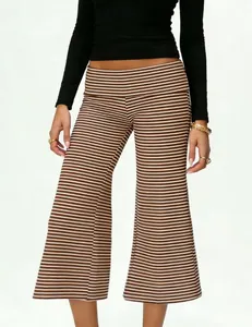 Detail of high-waisted brown and white striped flared pants with elastic waistband