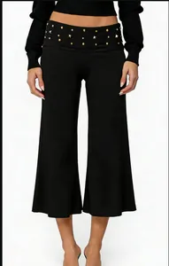 Detail of high waist black wide leg shorts featuring gold rivet studs and decorative trim