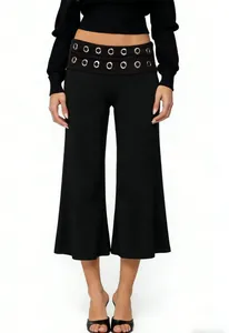 Detailed view of women's black wide-leg trousers featuring decorative silver metal eyelets
