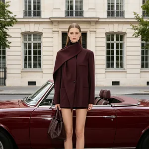 Macro detail of wine red blazer with asymmetrical scarf collar and leather handbag
