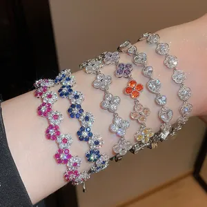 Detail showing multi-colored floral and heart-shaped sparkling stone bracelets on wrist