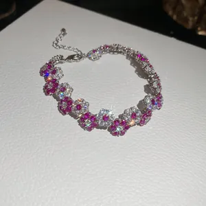 Elegant close-up of a silver-toned flower bracelet featuring magenta and white crystals.