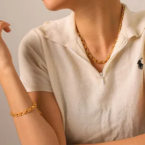 Gold stainless steel link chain necklace and bracelet set worn by a female model