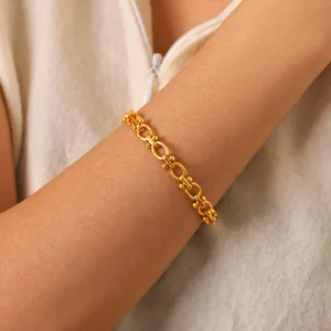 Elegant gold stainless steel link bracelet with spherical accents worn on a wrist