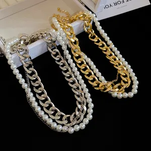 Detailed view of layered gold and silver chain necklaces with elegant pearls
