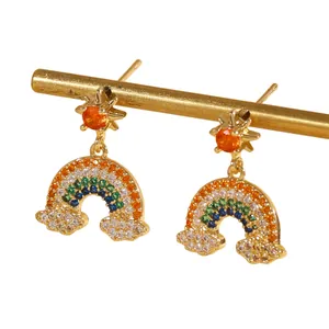 Detalle de los pendientes de nube y arcoíris con piedras de colores y botón de estrella dorada