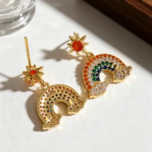 Primer plano de pendientes de sol y arcoíris con piedras de colores y baño de oro