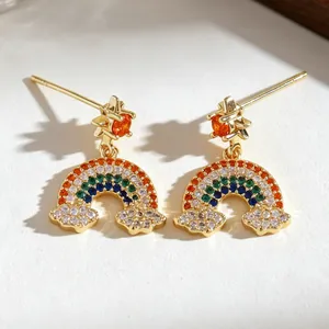Detalle de los pendientes de arcoíris bañados en oro con circonitas de colores