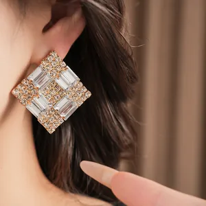 Detailed close-up showing the sparkling clear crystals on an elegant square stud earring