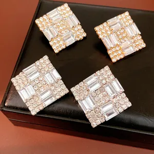 Detailed view of elegant square diamond-encrusted stud earrings on a jewelry box.